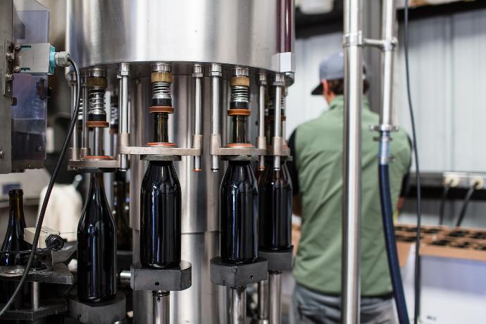 black glass bottles on stainless steel rack