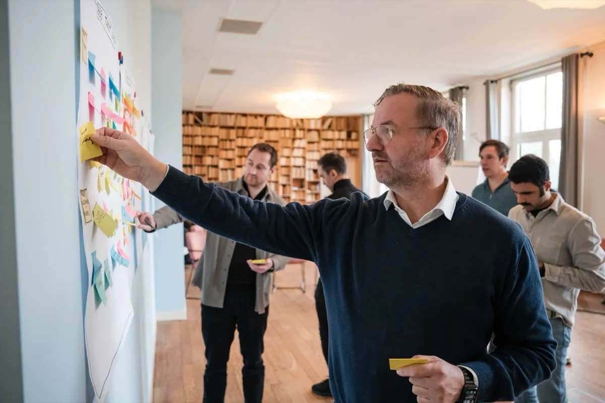 BrainStax AI Inspiratiesessie: team brainstormt met sticky notes op whiteboard